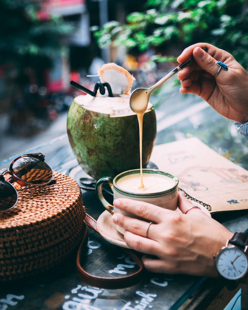 person holding silver spoon and gold cup