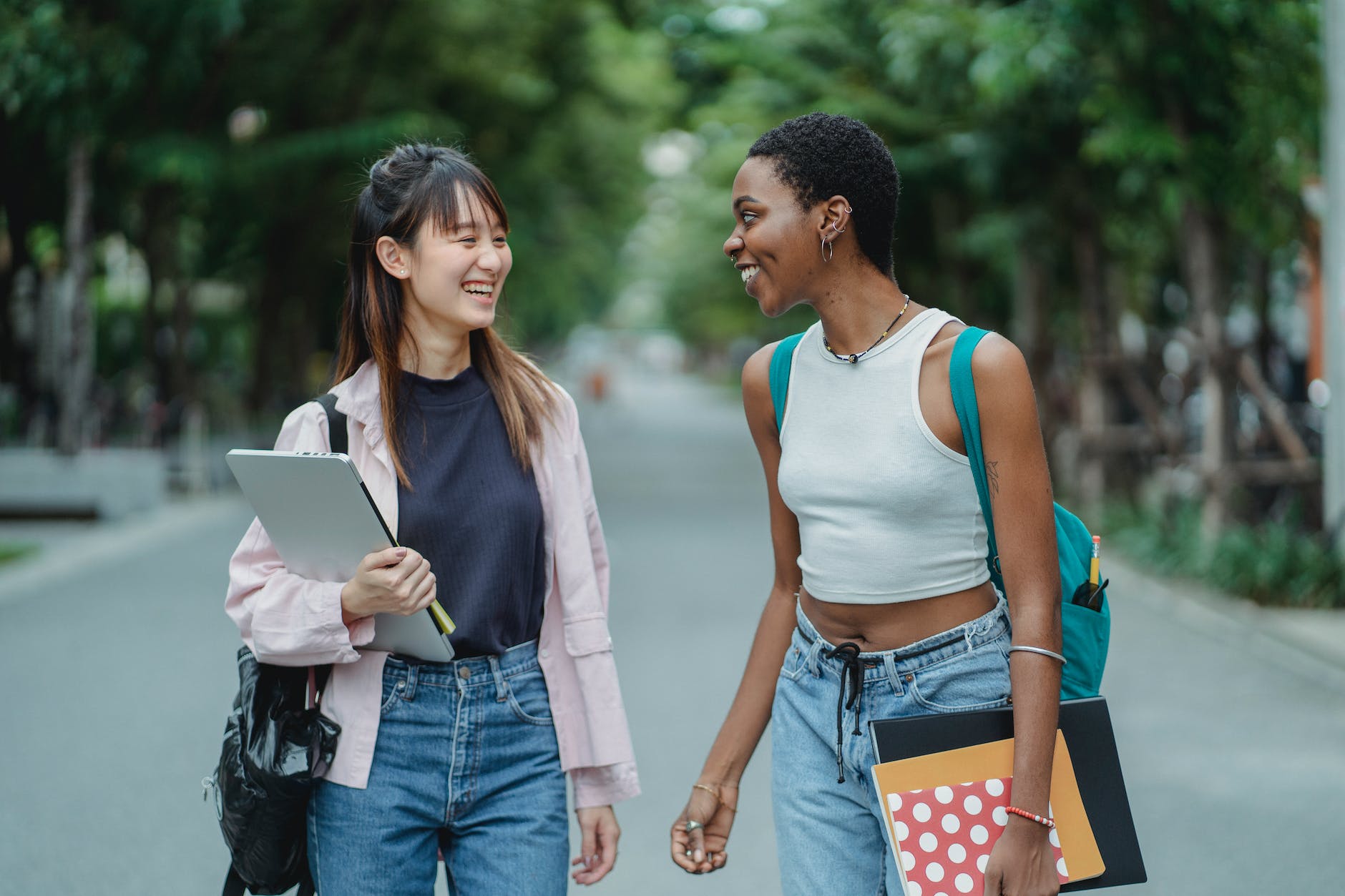 multiracial female friends talking wile standing on road