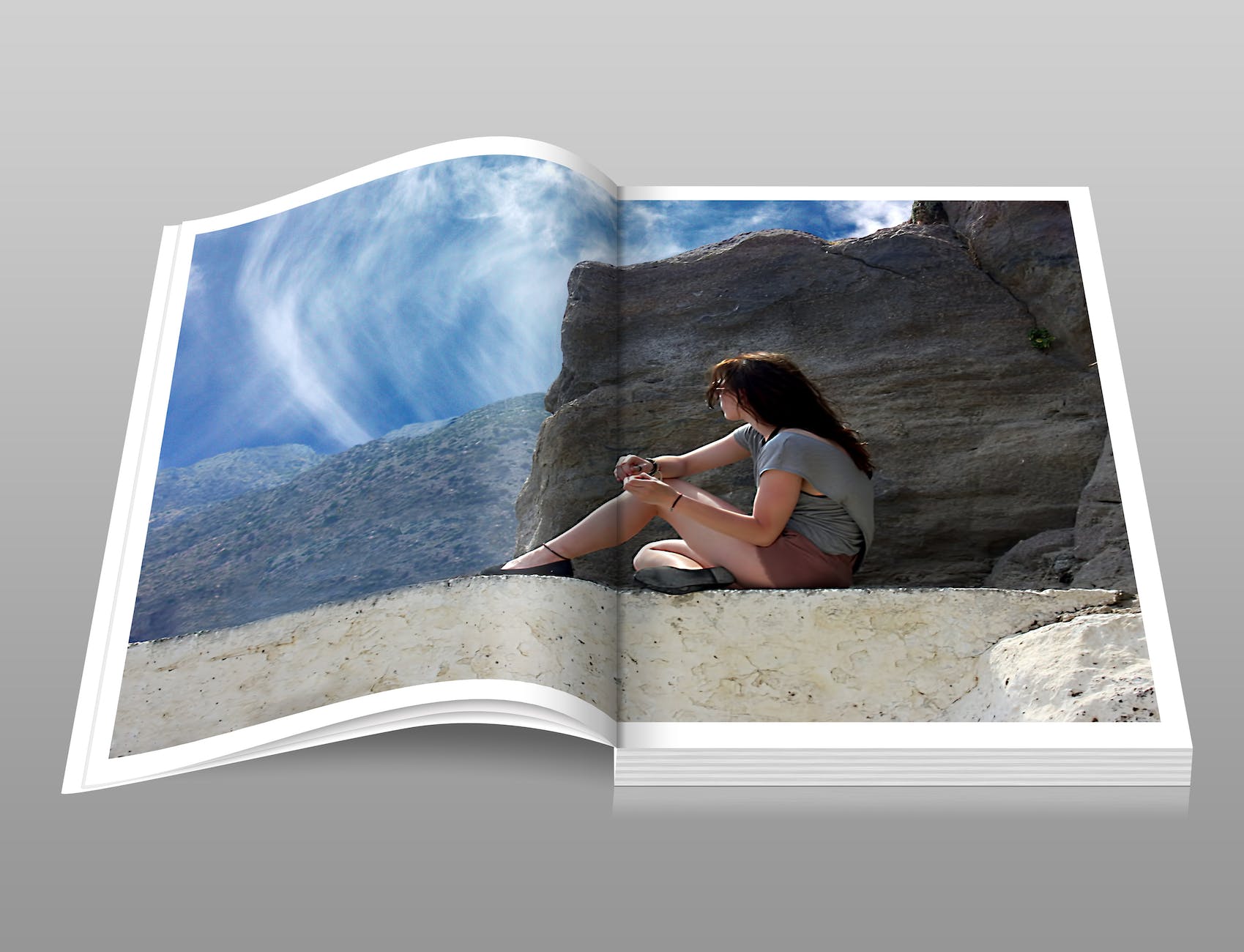 woman in gray shirt sitting over brown formation of rock during daytime book