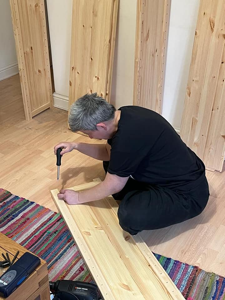 Woman dressed in black using a screw driver