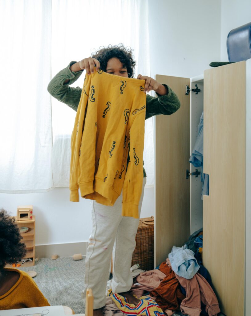 Women standing in front of wardrobe sorting through clothing