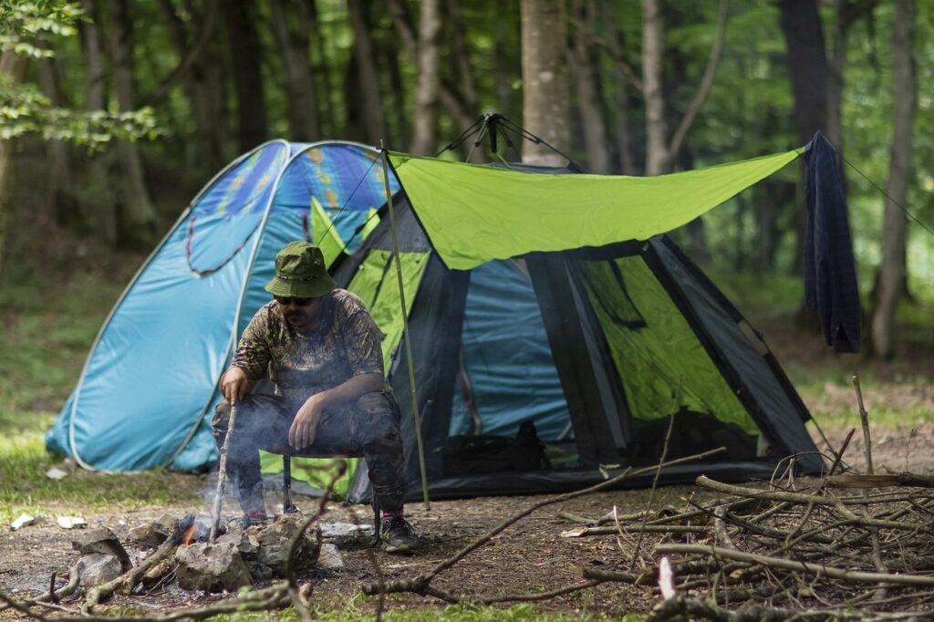 Man starting a fire outside his tent