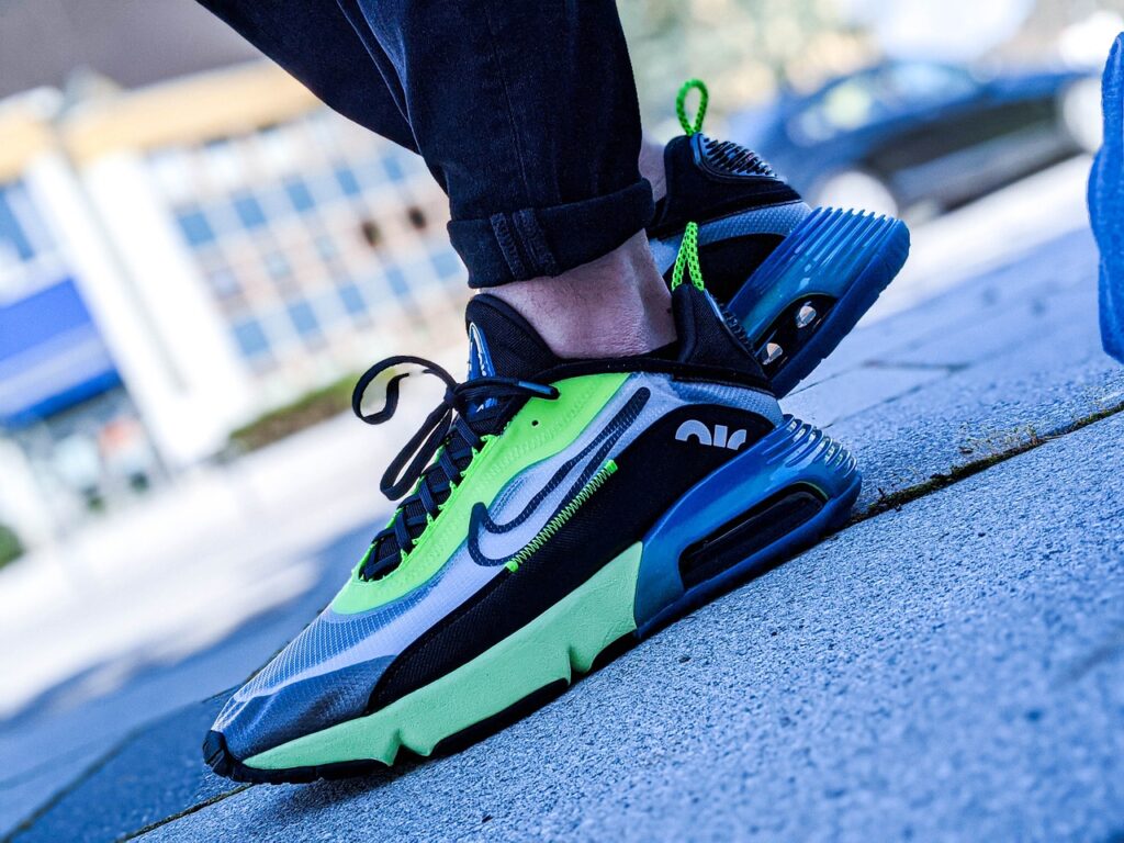 Person wearing yellow, black and blue Nike trainers