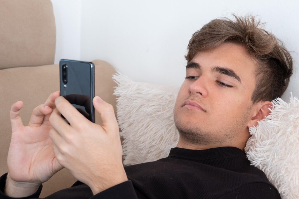 Man on sofa playing with phone