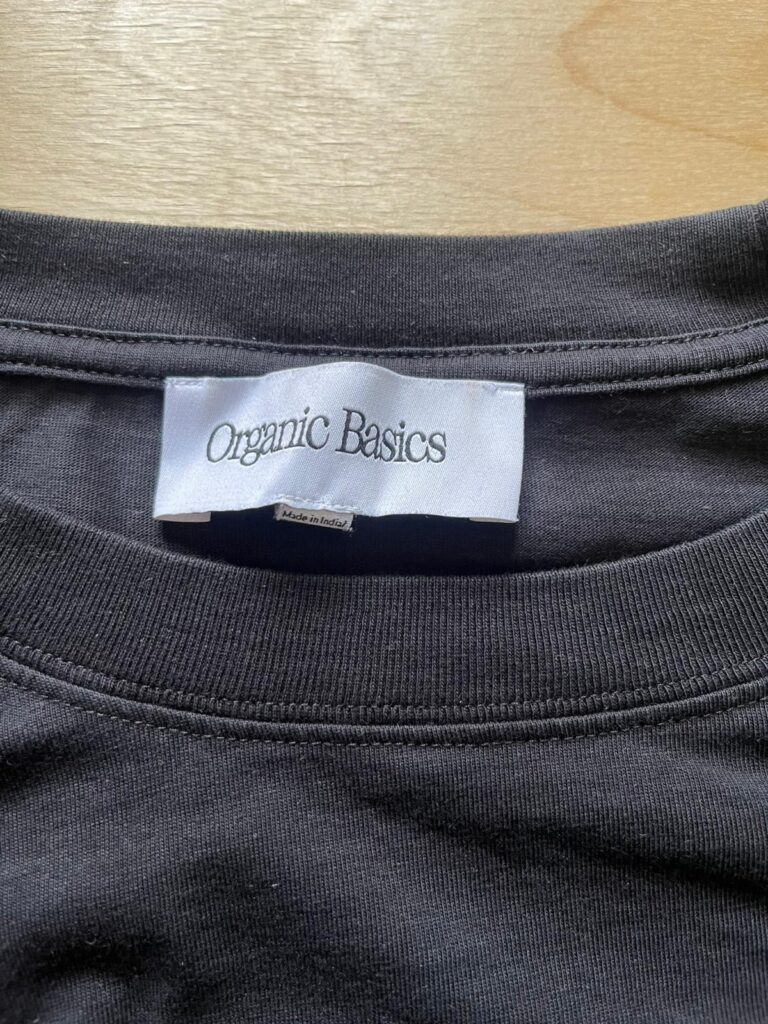 Organic Basics label as seen on a black T-Shirt
