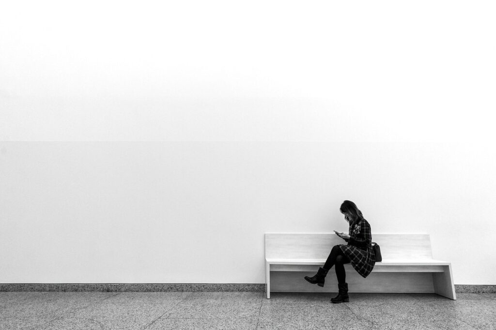 Women sitting on a bench in an otherwise empty room