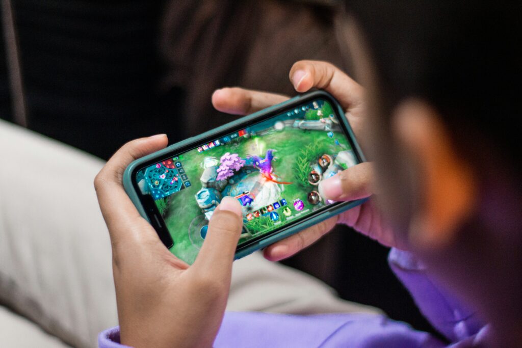 Person holding mobile phone between their hands playing a game