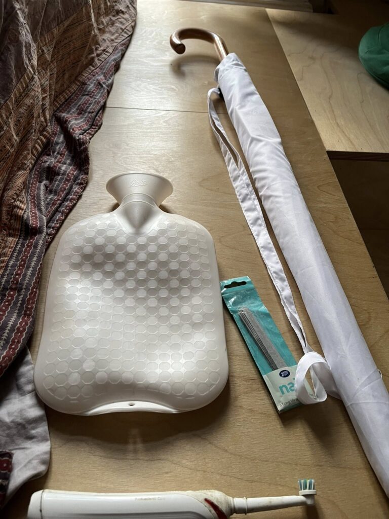 White umbrella, nail file, hot water bottle. toothbrush