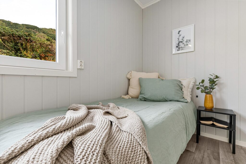 bedroom with bed, beside table and flowers
