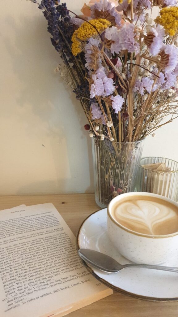 Table with cofee, flowers and a good book