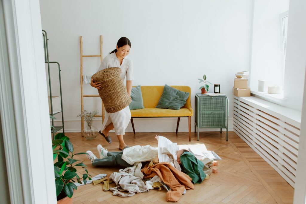 Child on floor covered in laundry